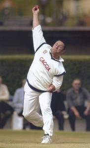 Shane Warne takes a sharp catch midway through his bowling action.